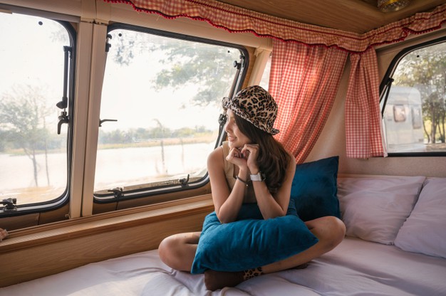 beautiful-young-asian-woman-relaxing-looking-view-motor-home-campsite-evening_49071-3000