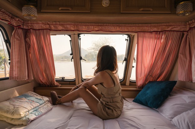 beautiful-young-asian-woman-relaxing-looking-view-motor-home-campsite-evening_49071-3001